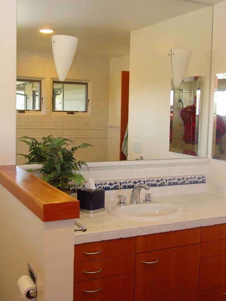 Пример оригинального дизайна: ванная комната среднего размера в восточном стиле с накладной раковиной, плоскими фасадами, фасадами цвета дерева среднего тона, столешницей из плитки, белой плиткой, керамической плиткой, белыми стенами и полом из керамической плитки