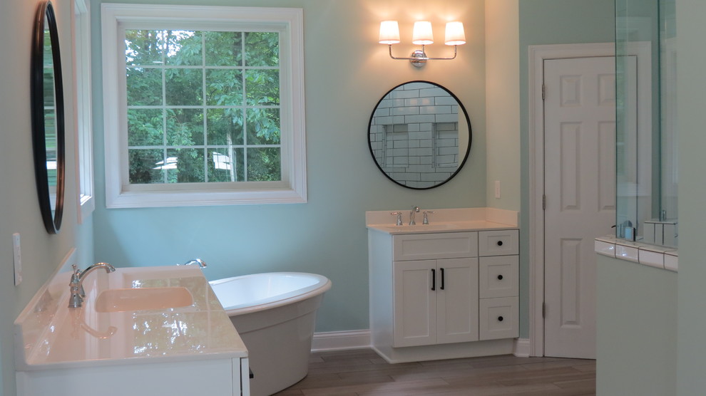Foto på ett stort funkis vit en-suite badrum, med skåp i shakerstil, vita skåp, ett fristående badkar, en dubbeldusch, vit kakel, keramikplattor, gröna väggar, klinkergolv i porslin, ett integrerad handfat, grått golv och med dusch som är öppen