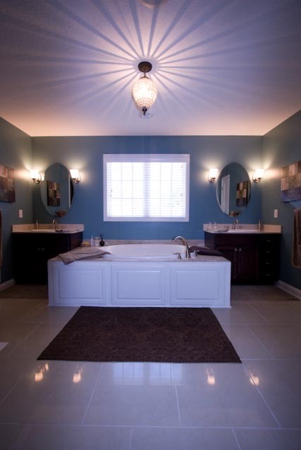 Idee per una grande stanza da bagno padronale tradizionale con ante in legno bruno, vasca da incasso, pareti blu, lavabo sottopiano, pavimento grigio e top grigio