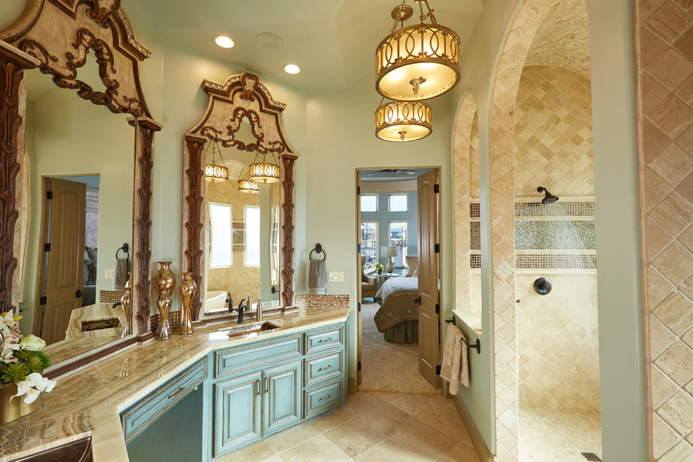 Стильный дизайн: огромная главная ванная комната в средиземноморском стиле с фасадами с выступающей филенкой, синими фасадами, столешницей из гранита, открытым душем, бежевой плиткой, керамической плиткой, бежевыми стенами, полом из керамической плитки, врезной раковиной и отдельно стоящей ванной - последний тренд