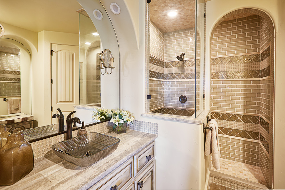 Photo of an expansive traditional shower room bathroom in Dallas with shaker cabinets, distressed cabinets, an alcove shower, a one-piece toilet, beige tiles, glass tiles, beige walls, ceramic flooring, a vessel sink, granite worktops, beige floors and beige worktops.