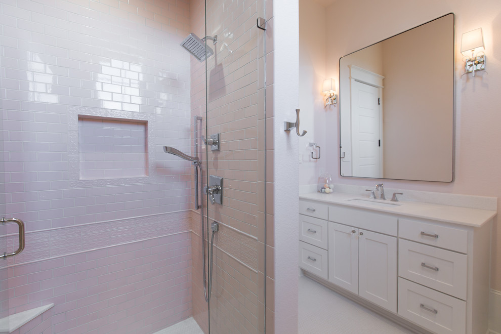 Exemple d'une salle de bain romantique de taille moyenne avec un placard à porte shaker, des portes de placard blanches, un carrelage gris, un carrelage métro, un mur rose, un sol en carrelage de porcelaine, un lavabo encastré, un plan de toilette en quartz modifié, un sol blanc et une cabine de douche à porte battante.