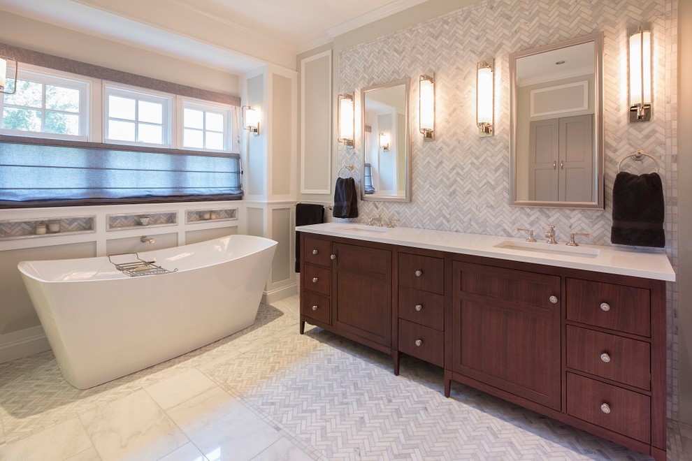 Стильный дизайн: большая главная ванная комната в стиле неоклассика (современная классика) с фасадами с утопленной филенкой, темными деревянными фасадами, отдельно стоящей ванной, душем в нише, унитазом-моноблоком, белой плиткой, мраморной плиткой, серыми стенами, мраморным полом, врезной раковиной, столешницей из искусственного кварца, белым полом, душем с распашными дверями и белой столешницей - последний тренд