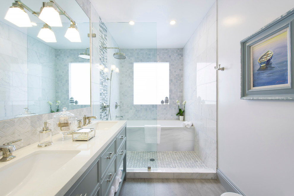 На фото: ванная комната в классическом стиле с врезной раковиной, серыми фасадами, ванной в нише, открытым душем, белой плиткой, белыми стенами, фасадами с утопленной филенкой, открытым душем и окном с