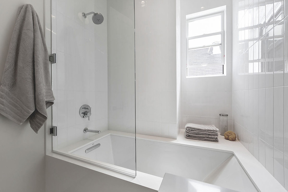 Стильный дизайн: ванная комната среднего размера в современном стиле с плоскими фасадами, темными деревянными фасадами, столешницей из искусственного кварца, ванной в нише, белой плиткой, керамической плиткой, белыми стенами и полом из керамогранита - последний тренд