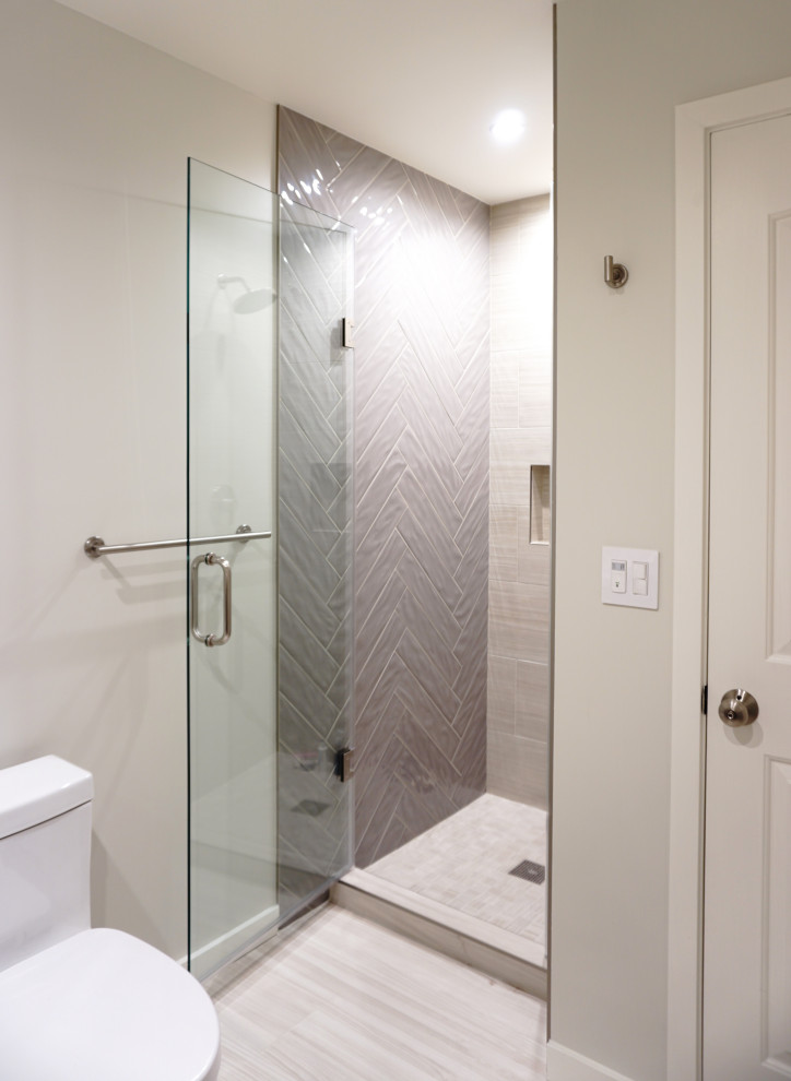 Example of a mid-sized trendy master beige tile and porcelain tile wood-look tile floor, beige floor and single-sink alcove shower design in San Francisco with flat-panel cabinets, dark wood cabinets, a one-piece toilet, white walls, an undermount sink, quartz countertops, a hinged shower door, white countertops, a niche and a built-in vanity