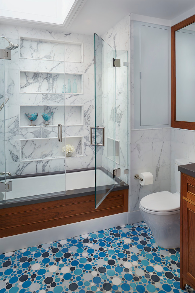 サンフランシスコにあるトランジショナルスタイルのおしゃれな浴室 (落し込みパネル扉のキャビネット、中間色木目調キャビネット、アンダーマウント型浴槽、シャワー付き浴槽	、分離型トイレ、グレーの壁、モザイクタイル) の写真