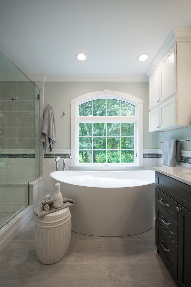 Bathroom - large traditional master gray tile and subway tile porcelain tile and gray floor bathroom idea in Providence with recessed-panel cabinets, dark wood cabinets, gray walls, an undermount sink, granite countertops, a hinged shower door and gray countertops