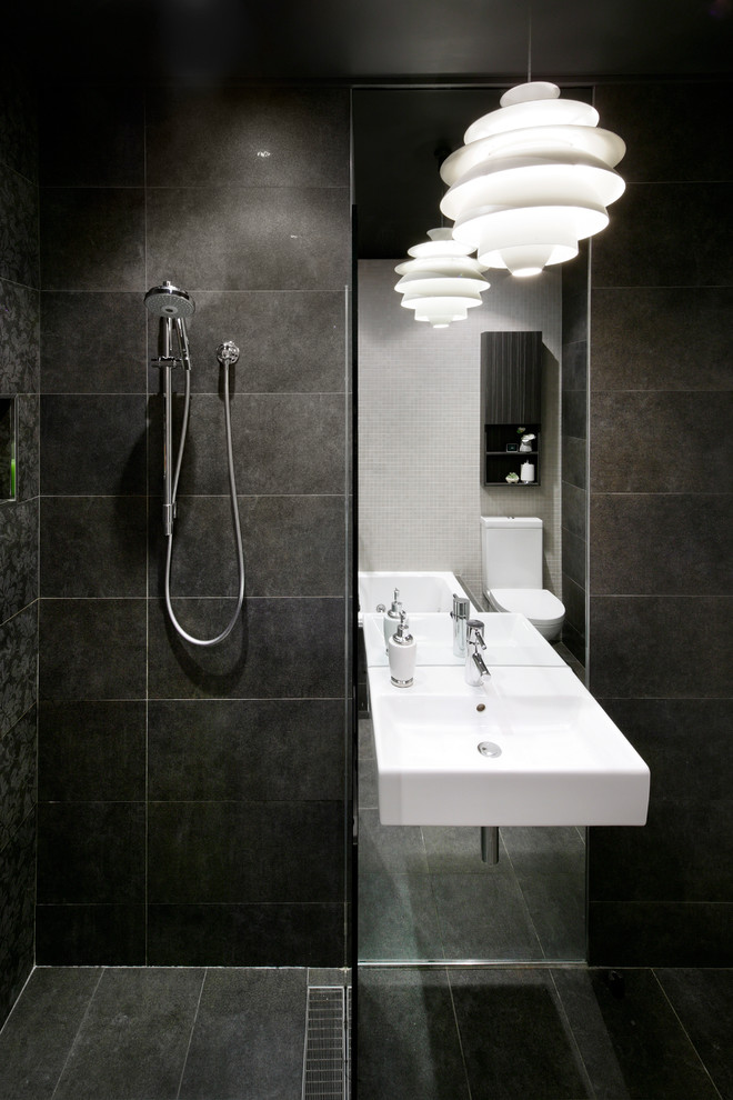 На фото: главная ванная комната в современном стиле с открытым душем, унитазом-моноблоком, черной плиткой и черными стенами с