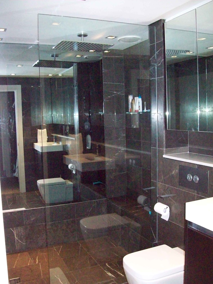 На фото: ванная комната среднего размера в стиле модернизм с монолитной раковиной, столешницей из искусственного камня, отдельно стоящей ванной, душем над ванной, инсталляцией, коричневой плиткой, керамогранитной плиткой, коричневыми стенами, полом из керамогранита и душевой кабиной с