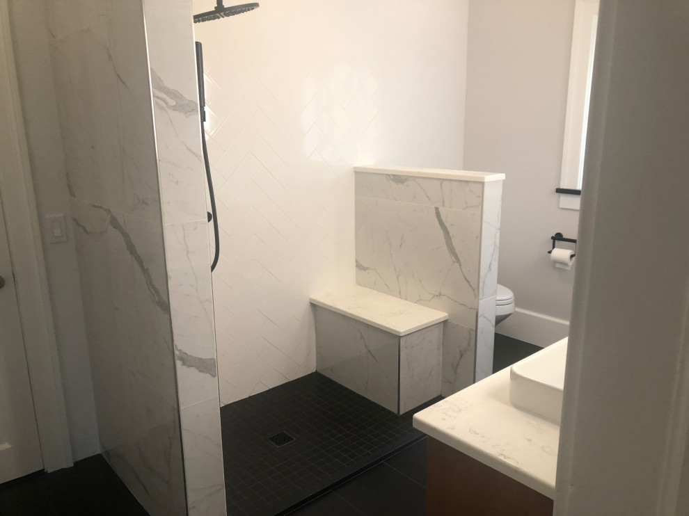 Пример оригинального дизайна: ванная комната среднего размера в стиле модернизм с плоскими фасадами, коричневыми фасадами, душем в нише, раздельным унитазом, белой плиткой, керамической плиткой, серыми стенами, полом из керамической плитки, душевой кабиной, настольной раковиной, столешницей из искусственного кварца, черным полом, душем с раздвижными дверями, белой столешницей, сиденьем для душа, тумбой под две раковины и подвесной тумбой
