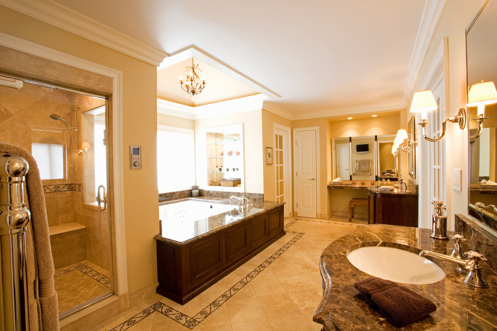 Exemple d'une très grande salle de bain principale chic en bois brun avec un placard en trompe-l'oeil, un plan de toilette en marbre, une baignoire encastrée, une douche double, un carrelage marron, un carrelage de pierre, un lavabo encastré, WC séparés et un mur gris.