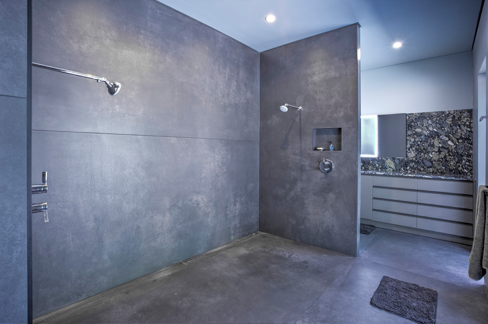 Large minimalist master gray tile and porcelain tile porcelain tile, gray floor and double-sink bathroom photo in New York with flat-panel cabinets, gray cabinets, a wall-mount toilet, gray walls, granite countertops, gray countertops and a built-in vanity