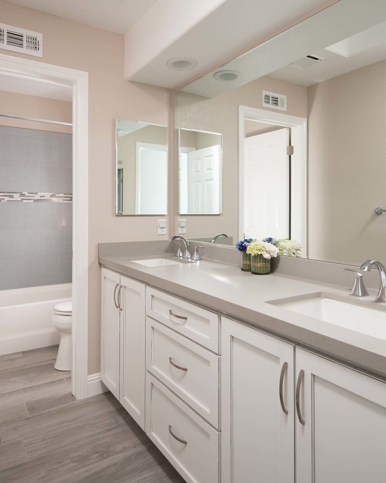 Inspiration for a mid-sized contemporary kids' gray tile and porcelain tile porcelain tile drop-in bathtub remodel in San Diego with an undermount sink, shaker cabinets, white cabinets, quartz countertops, a one-piece toilet and beige walls