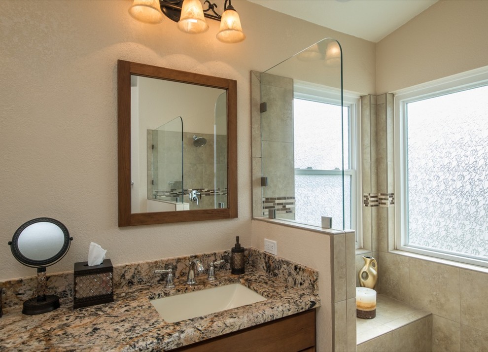 Modelo de cuarto de baño actual con lavabo encastrado, encimera de granito, ducha abierta y baldosas y/o azulejos beige