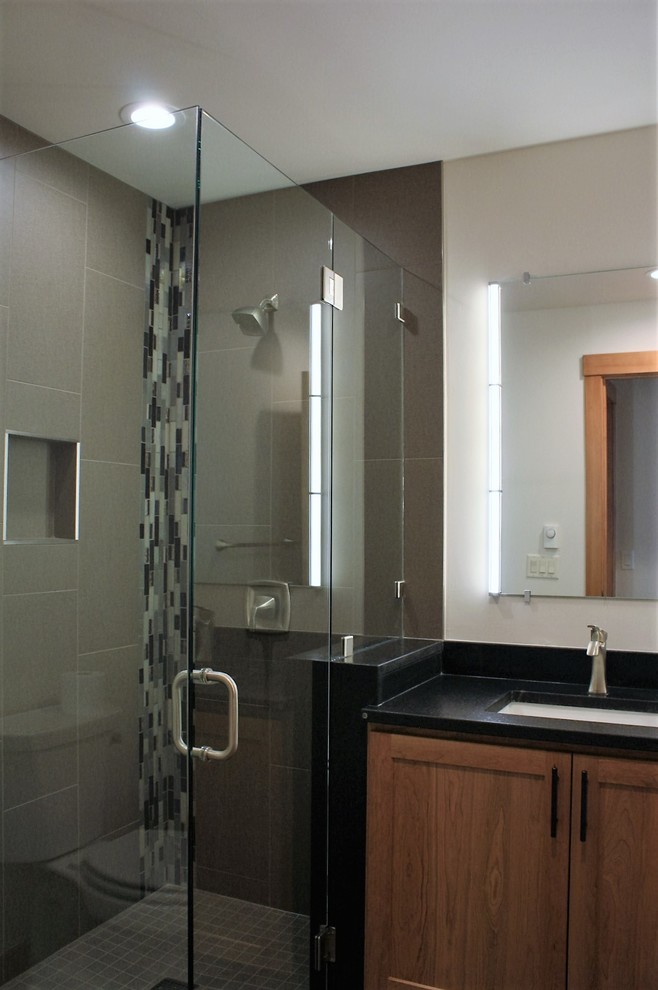 Example of a gray tile and porcelain tile corner shower design in Other with an undermount sink and granite countertops