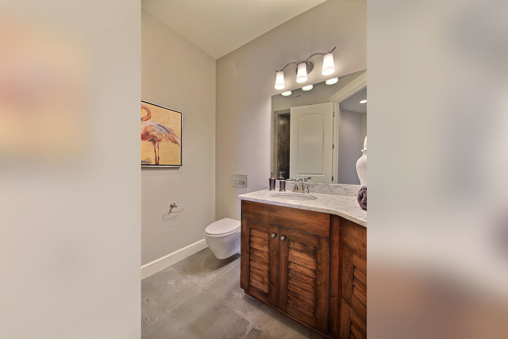 Example of a mid-sized transitional 3/4 gray tile and cement tile concrete floor walk-in shower design in Portland with louvered cabinets, medium tone wood cabinets, a wall-mount toilet, gray walls, an undermount sink and quartz countertops