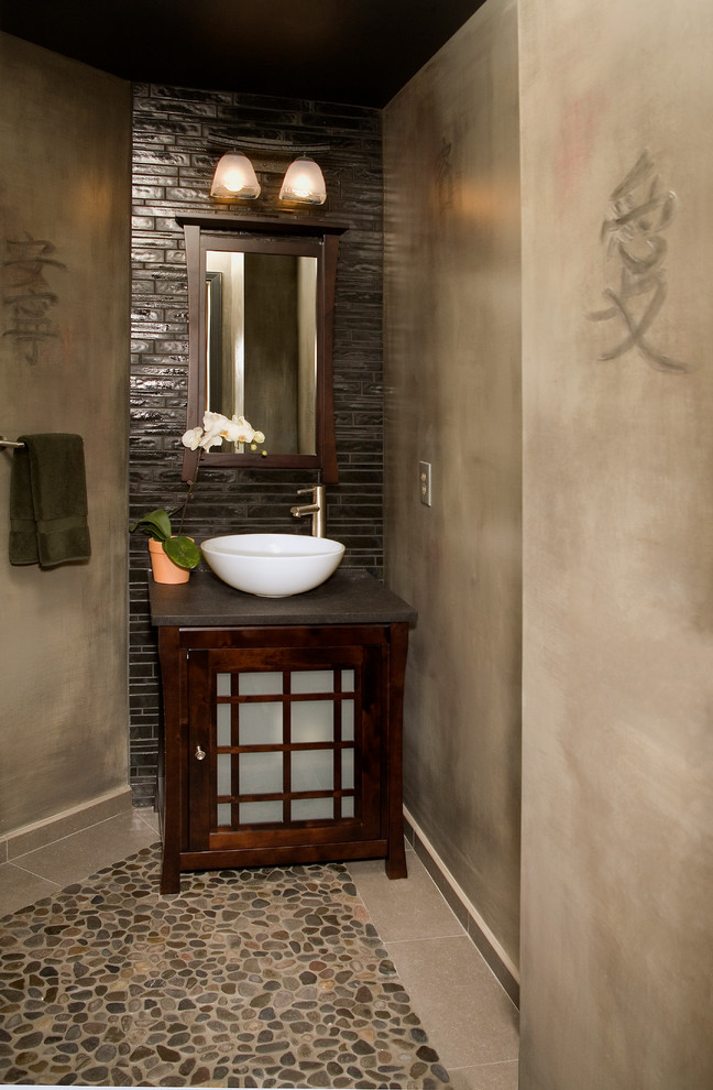 Foto på ett litet orientaliskt badrum, med luckor med glaspanel, skåp i mellenmörkt trä, bänkskiva i kvarts, brun kakel, stenhäll, beige väggar, klinkergolv i småsten och ett fristående handfat