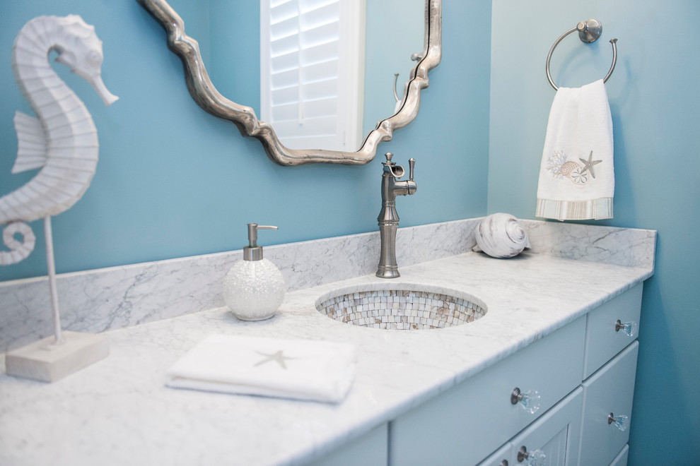 Mid-sized beach style 3/4 mosaic tile marble floor bathroom photo in Philadelphia with raised-panel cabinets, white cabinets, marble countertops, blue walls, a two-piece toilet and an undermount sink