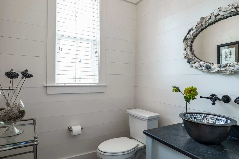 Cette image montre une petite salle d'eau traditionnelle avec un placard en trompe-l'oeil, un mur blanc, un sol en bois brun, une vasque, un plan de toilette en stéatite et des portes de placard grises.
