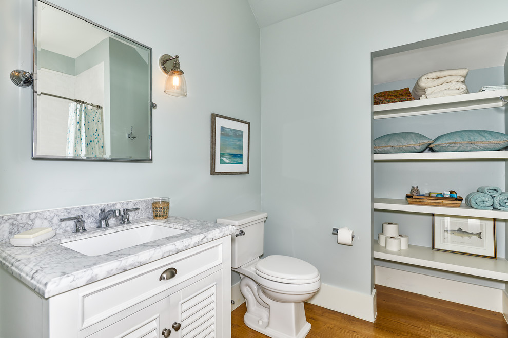 На фото: ванная комната среднего размера в морском стиле с белыми фасадами, инсталляцией, синими стенами, паркетным полом среднего тона, накладной раковиной, столешницей из кварцита, коричневым полом и белой столешницей с