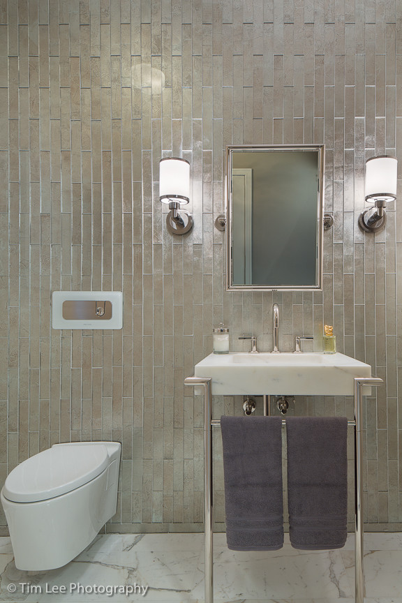 Inredning av ett modernt litet badrum, med ett konsol handfat, öppna hyllor, marmorbänkskiva, en vägghängd toalettstol och marmorgolv