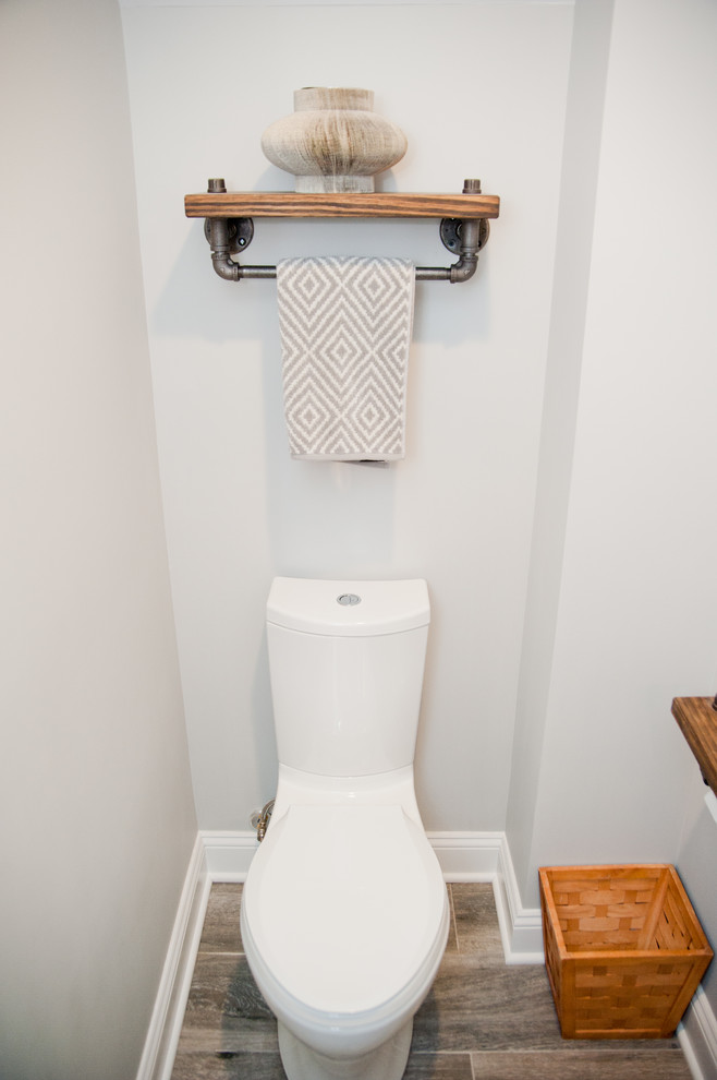 ニューヨークにあるお手頃価格の小さなラスティックスタイルのおしゃれなトイレ・洗面所 (オープンシェルフ、一体型トイレ	、グレーの壁、濃色無垢フローリング、ベッセル式洗面器、木製洗面台) の写真