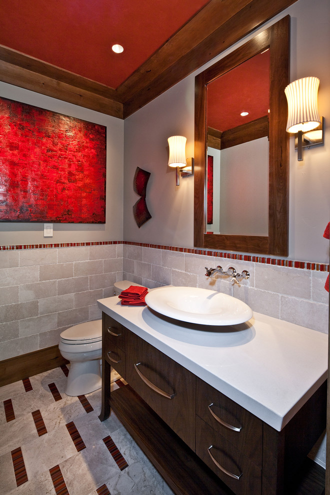 Exemple d'une salle de bain tendance avec une vasque, un sol multicolore et un mur en pierre.