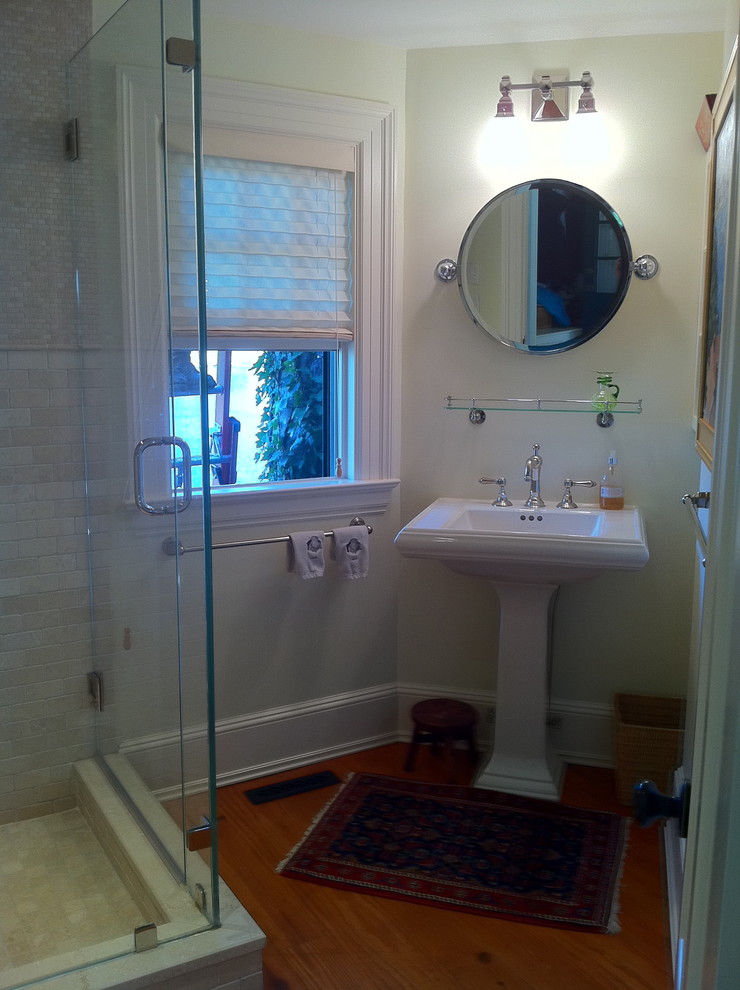 Idee per una stanza da bagno tradizionale con doccia ad angolo, pareti bianche, lavabo a colonna, pavimento marrone e porta doccia a battente