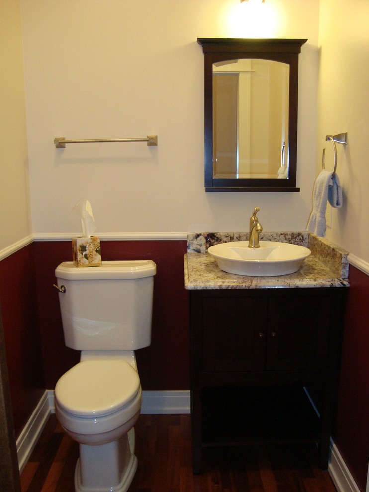 Modelo de cuarto de baño contemporáneo pequeño con paredes multicolor, lavabo sobreencimera, puertas de armario de madera en tonos medios, sanitario de dos piezas, suelo de madera en tonos medios, encimera de granito y aseo y ducha
