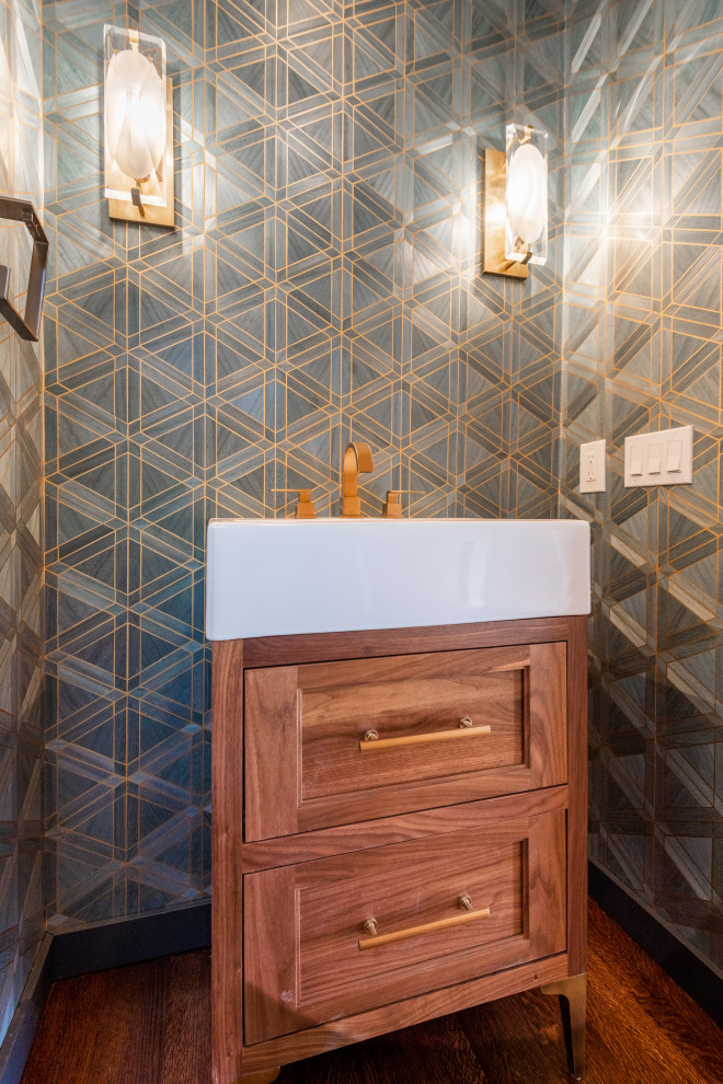 Cette image montre une petite salle d'eau traditionnelle en bois brun avec un placard avec porte à panneau encastré, un mur bleu, un sol en bois brun, un plan vasque, un sol marron, meuble simple vasque, meuble-lavabo sur pied et du papier peint.