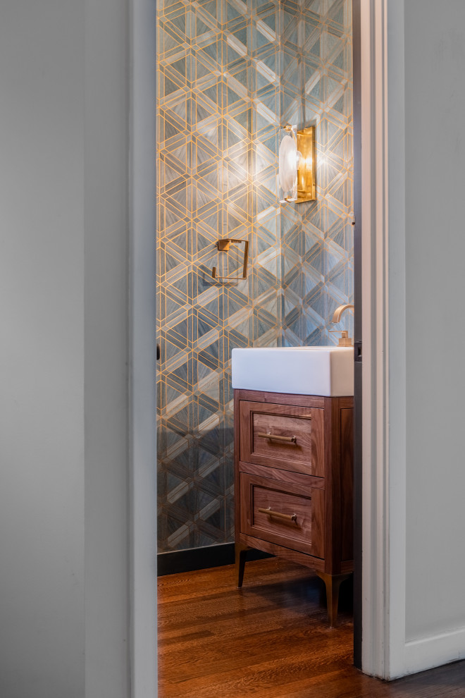 Photo of a small traditional cloakroom in Providence with recessed-panel cabinets, medium wood cabinets, medium hardwood flooring, a console sink, brown floors, a freestanding vanity unit and wallpapered walls.