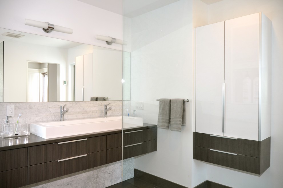 Inredning av ett modernt mellanstort en-suite badrum, med släta luckor, grå skåp, en kantlös dusch, en toalettstol med hel cisternkåpa, grå kakel, stenkakel, vita väggar, klinkergolv i porslin, ett fristående handfat och bänkskiva i kvartsit