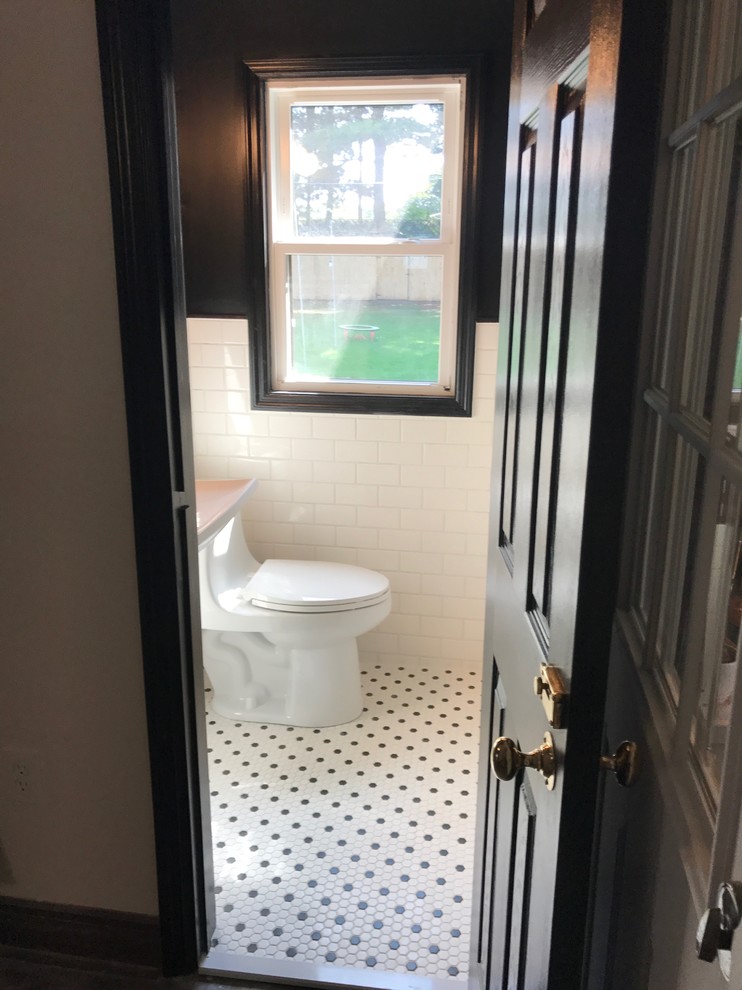 Kleines Retro Badezimmer mit Toilette mit Aufsatzspülkasten, weißen Fliesen, Metrofliesen, schwarzer Wandfarbe, Keramikboden, Wandwaschbecken und weißem Boden in New York