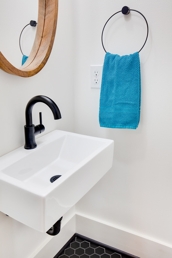 Foto de cuarto de baño de estilo americano pequeño con sanitario de una pieza, paredes blancas, suelo de baldosas de cerámica, lavabo suspendido y suelo negro