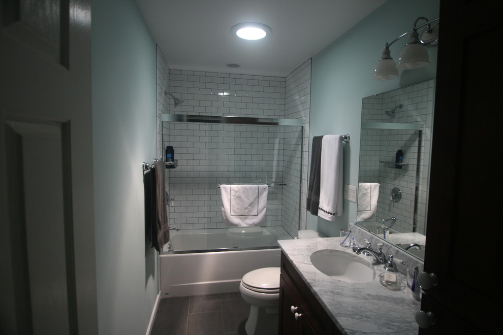 Inspiration pour une salle de bain traditionnelle en bois foncé de taille moyenne avec un placard avec porte à panneau encastré, une baignoire en alcôve, un combiné douche/baignoire, WC séparés, un mur bleu, un lavabo encastré, un plan de toilette en marbre et une cabine de douche à porte coulissante.