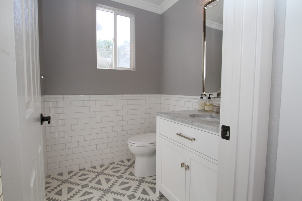 Photo of a small contemporary bathroom in Orange County with shaker cabinets, white cabinets, a one-piece toilet, white tiles, metro tiles, grey walls, cement flooring, a submerged sink, marble worktops and multi-coloured floors.