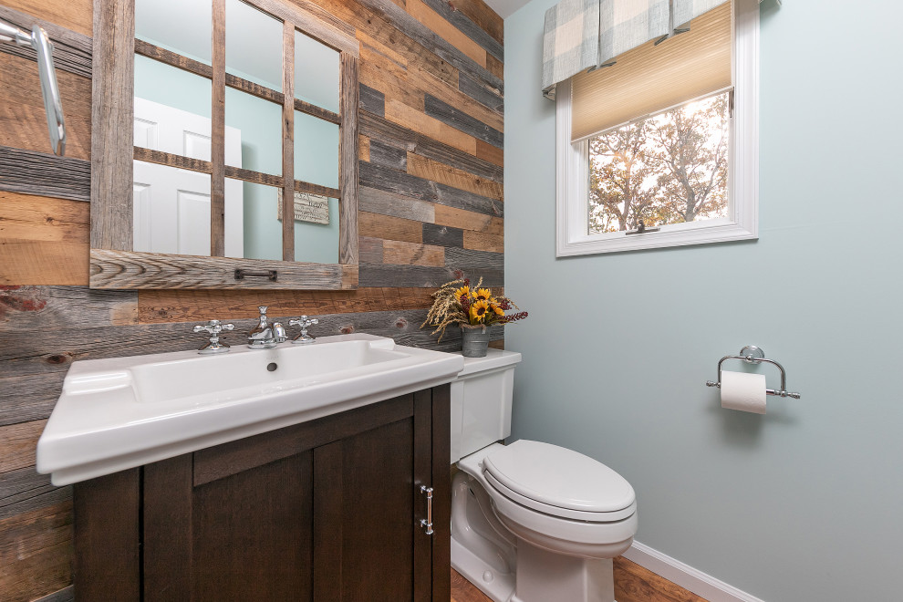 Réalisation d'une petite salle de bain tradition avec un placard en trompe-l'oeil, des portes de placard marrons, un mur bleu, un lavabo intégré et un sol marron.