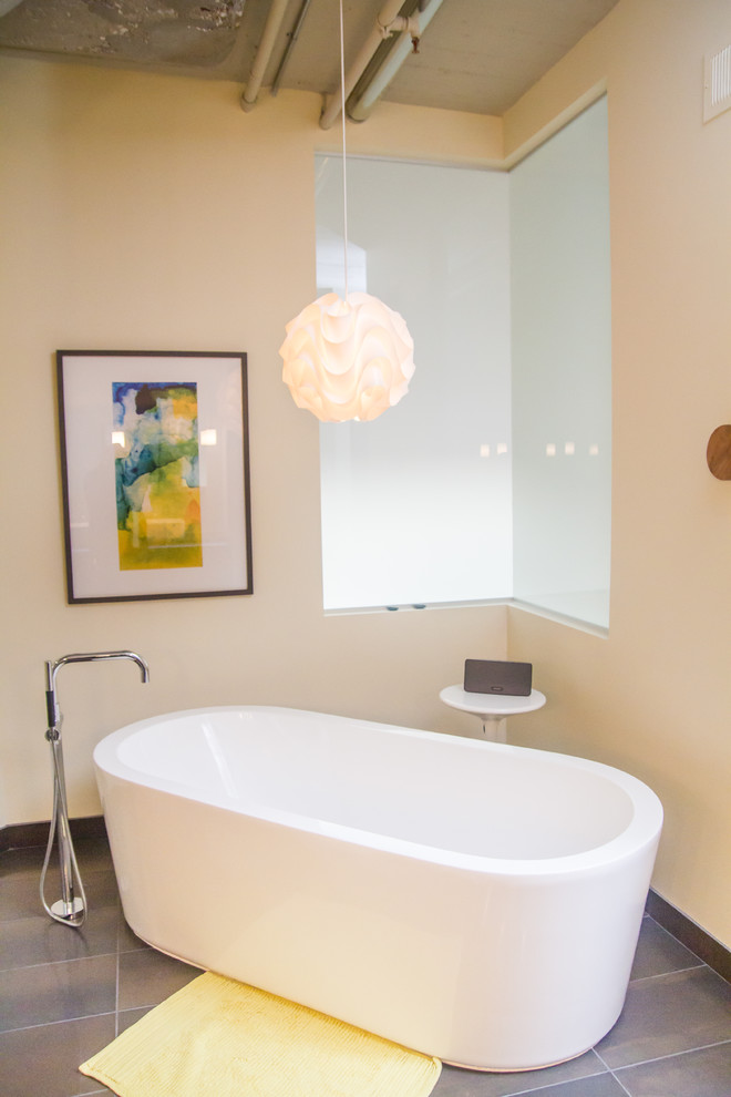 Foto de cuarto de baño principal contemporáneo grande con bañera exenta, paredes beige, suelo de pizarra y suelo gris