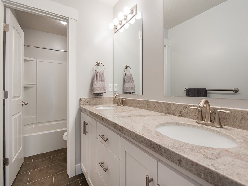 Mid-sized arts and crafts 3/4 ceramic tile bathroom photo in Salt Lake City with recessed-panel cabinets, white cabinets, quartzite countertops and gray walls