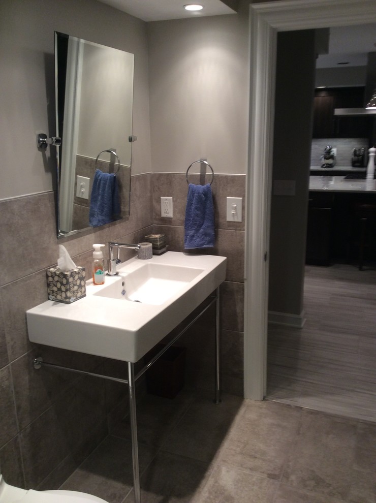 Medium sized contemporary shower room bathroom in Columbus with an alcove shower, a one-piece toilet, grey tiles, grey walls, cement flooring, grey floors, a hinged door, stone tiles, a console sink and solid surface worktops.