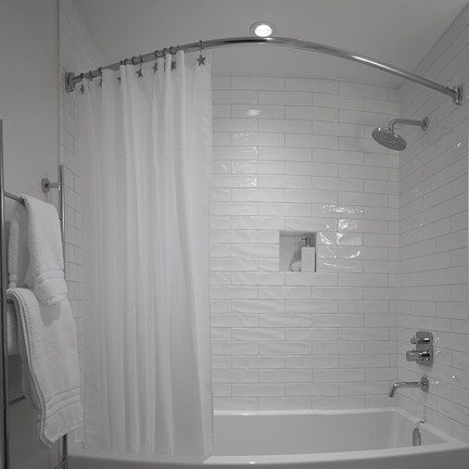 Cette image montre une petite salle de bain principale design avec un placard à porte plane, des portes de placard blanches, une baignoire en alcôve, un combiné douche/baignoire, un carrelage blanc, des carreaux de céramique, un sol en carrelage de terre cuite, un lavabo encastré, un plan de toilette en granite et un mur blanc.