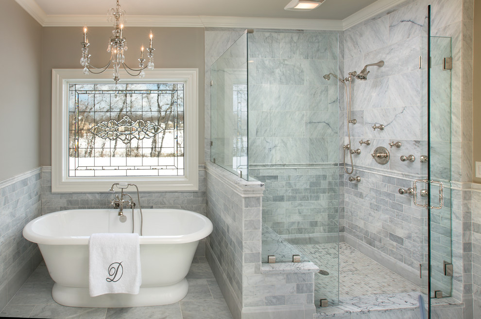 Стильный дизайн: большая главная ванная комната в классическом стиле с врезной раковиной, мраморной столешницей, отдельно стоящей ванной, двойным душем, серой плиткой, каменной плиткой, серыми стенами и мраморным полом - последний тренд