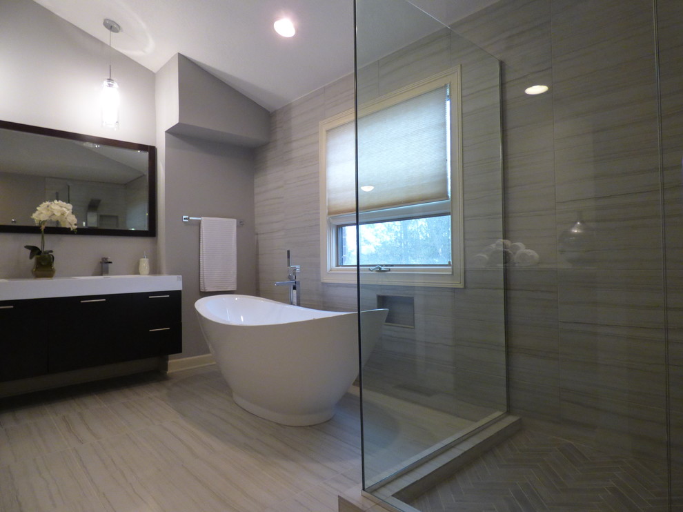Cette photo montre une grande salle de bain principale chic en bois foncé avec un placard en trompe-l'oeil, une baignoire indépendante, une douche d'angle, un carrelage gris, un carrelage de pierre, un mur gris, un sol en marbre et un plan vasque.