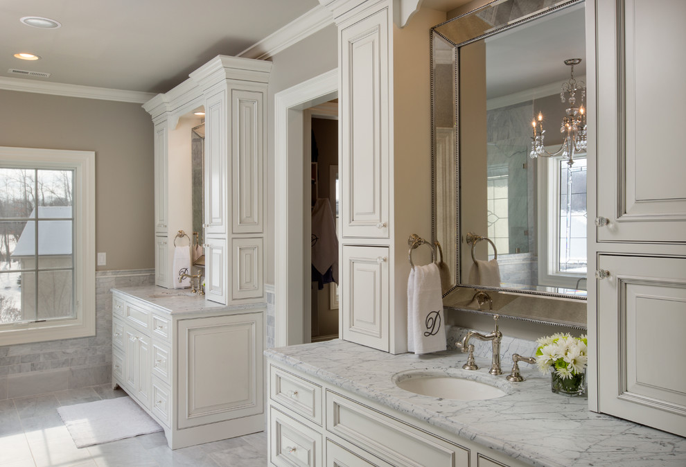 Идея дизайна: большая главная ванная комната в классическом стиле с врезной раковиной, белыми фасадами, мраморной столешницей, серой плиткой, каменной плиткой, серыми стенами, мраморным полом и фасадами с утопленной филенкой