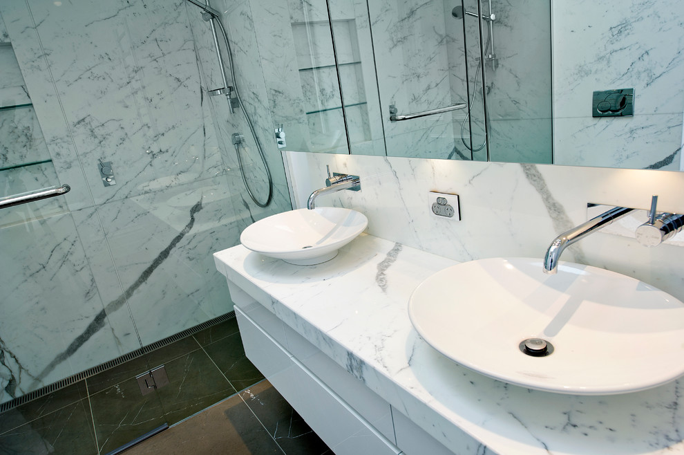 Esempio di una grande stanza da bagno padronale design con doccia a filo pavimento, pavimento in marmo, top in marmo, porta doccia a battente e due lavabi