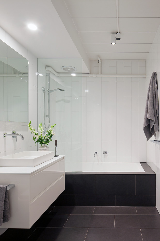 Inredning av ett modernt mellanstort badrum, med vita skåp, ett platsbyggt badkar, en dusch/badkar-kombination, vita väggar, släta luckor, vit kakel, keramikplattor, ett fristående handfat och med dusch som är öppen