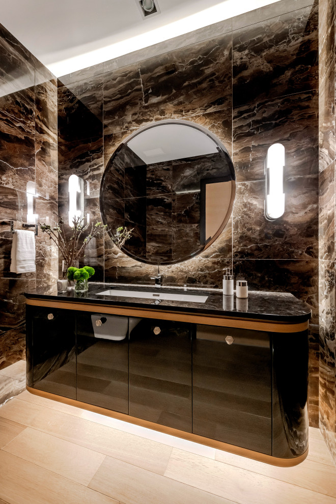 Large trendy multicolored tile and marble tile light wood floor and white floor bathroom photo in Other with flat-panel cabinets, black cabinets, a wall-mount toilet, multicolored walls, an undermount sink, marble countertops and black countertops