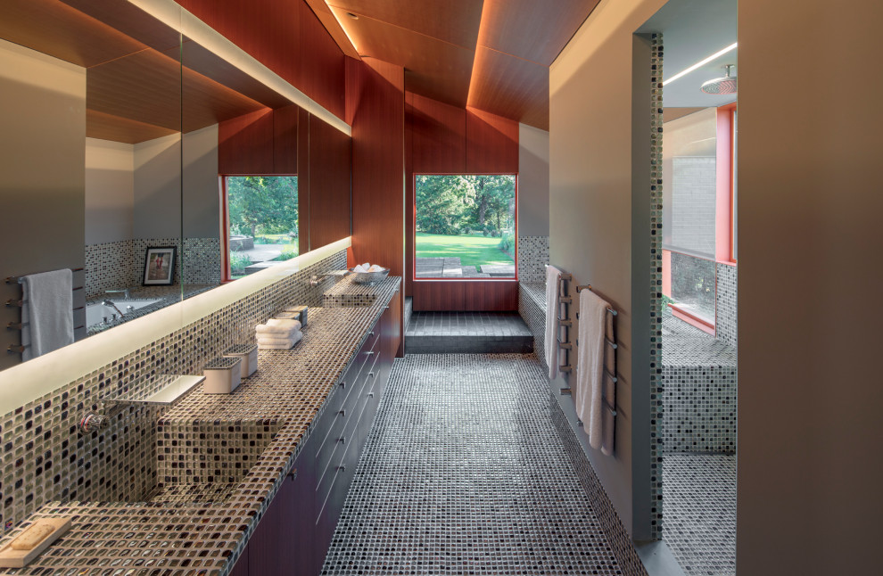 Пример оригинального дизайна: главная ванная комната в современном стиле с плоскими фасадами, темными деревянными фасадами, серой плиткой, плиткой мозаикой, серыми стенами, полом из мозаичной плитки, монолитной раковиной, столешницей из плитки, серым полом и серой столешницей