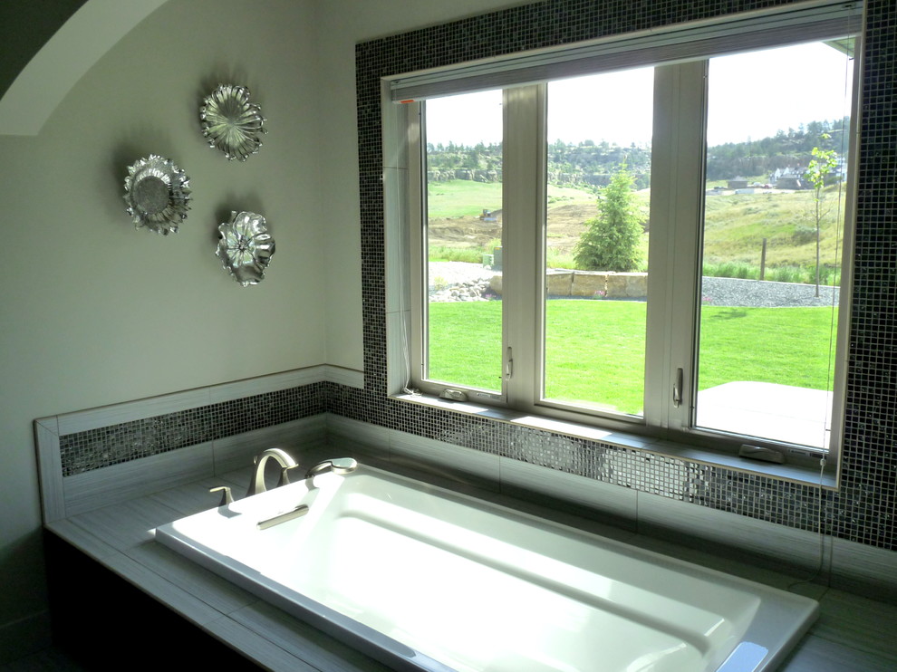 This is an example of a medium sized contemporary ensuite bathroom in Other with a submerged sink, recessed-panel cabinets, dark wood cabinets, engineered stone worktops, a built-in bath, a walk-in shower, a two-piece toilet, grey tiles, porcelain tiles, grey walls and porcelain flooring.